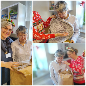 Rozdawanie prezentów na oddziale 3A. Mieszkanka pozuje do zdjęcia z podarunkami od Mikołaja.