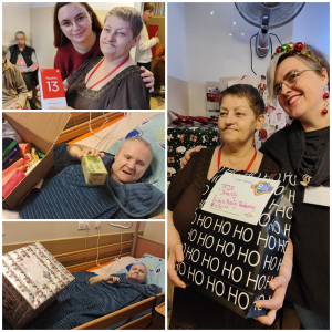 Rozdawanie prezentów na oddziale 3A. Mieszkanka pozuje do zdjęcia z podarunkami od Mikołaja.