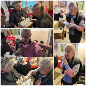 Rozdawanie prezentów na oddziale 3A. Mieszkanka pozuje do zdjęcia z podarunkami od Mikołaja.