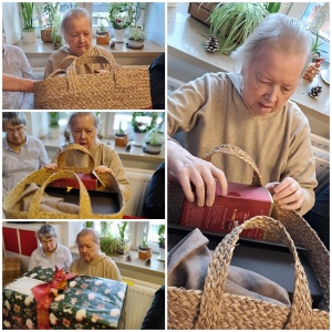 Rozdawanie prezentów na oddziale 3A. Mieszkanka pozuje do zdjęcia z podarunkami od Mikołaja.