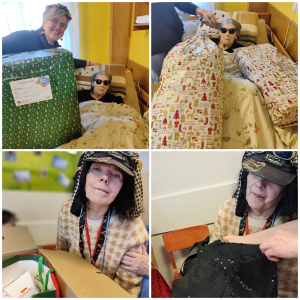 Rozdawanie prezentów na oddziale 3A. Mieszkanka pozuje do zdjęcia z podarunkami od Mikołaja.