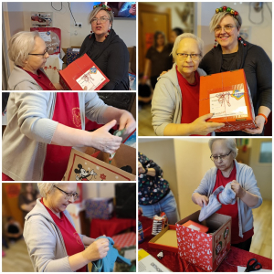 Rozdawanie prezentów na oddziale 3A. Mieszkanka pozuje do zdjęcia z podarunkami od Mikołaja.