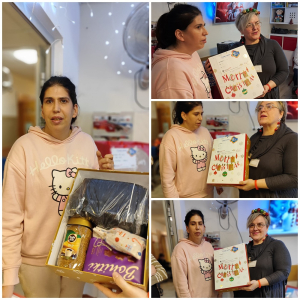 Rozdawanie prezentów na oddziale 3A. Mieszkanka pozuje do zdjęcia z podarunkami od Mikołaja.