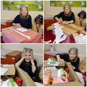 Rozdawanie prezentów na oddziale 3A. Mieszkanka pozuje do zdjęcia z podarunkami od Mikołaja.