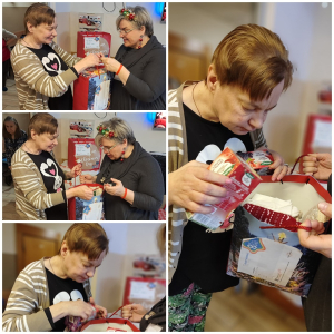 Rozdawanie prezentów na oddziale 3A. Mieszkanka pozuje do zdjęcia z podarunkami od Mikołaja.