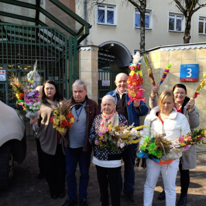 Zdjęcia pamiątkowe z wyjazdu do caritas - Mieszkańcy z palmami pod DPS. 