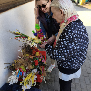 Mieszkanka i pracownik Caritas - przekazanie palm. 