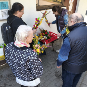 Na zdjęciu pracownik dps, dwoje mieszkańców dps i pracownik caritas. Moment przekazania palm.