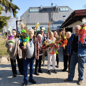 Zdjęcia grupowe Mieszkańców z palmami na terenie Caritas. 