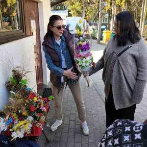 Mieszkanka i pracownik Caritas - przekazanie palm. 